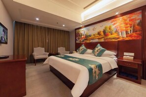 A hotel room with a large bed, a desk, a chair, and a painting on the wall.