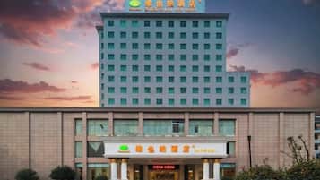 Un hotel con fachada moderna, entrada destacada y un letrero que indica un restaurante.