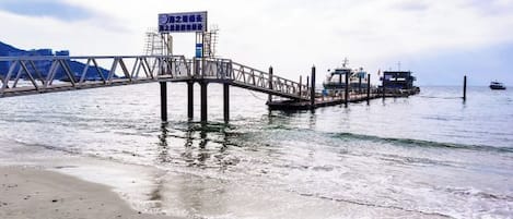 A pier extending into calm water with a clear sky above.