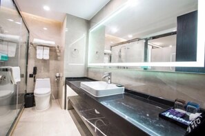 A modern bathroom with a glass-enclosed shower, a white toilet, a black marble countertop, and a large mirror. - Xi . Hotel (Huidong)