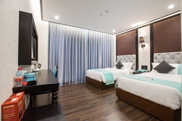 A hotel room with two beds, a desk, a coffee maker, and a TV. - Xi . Hotel (Huidong)