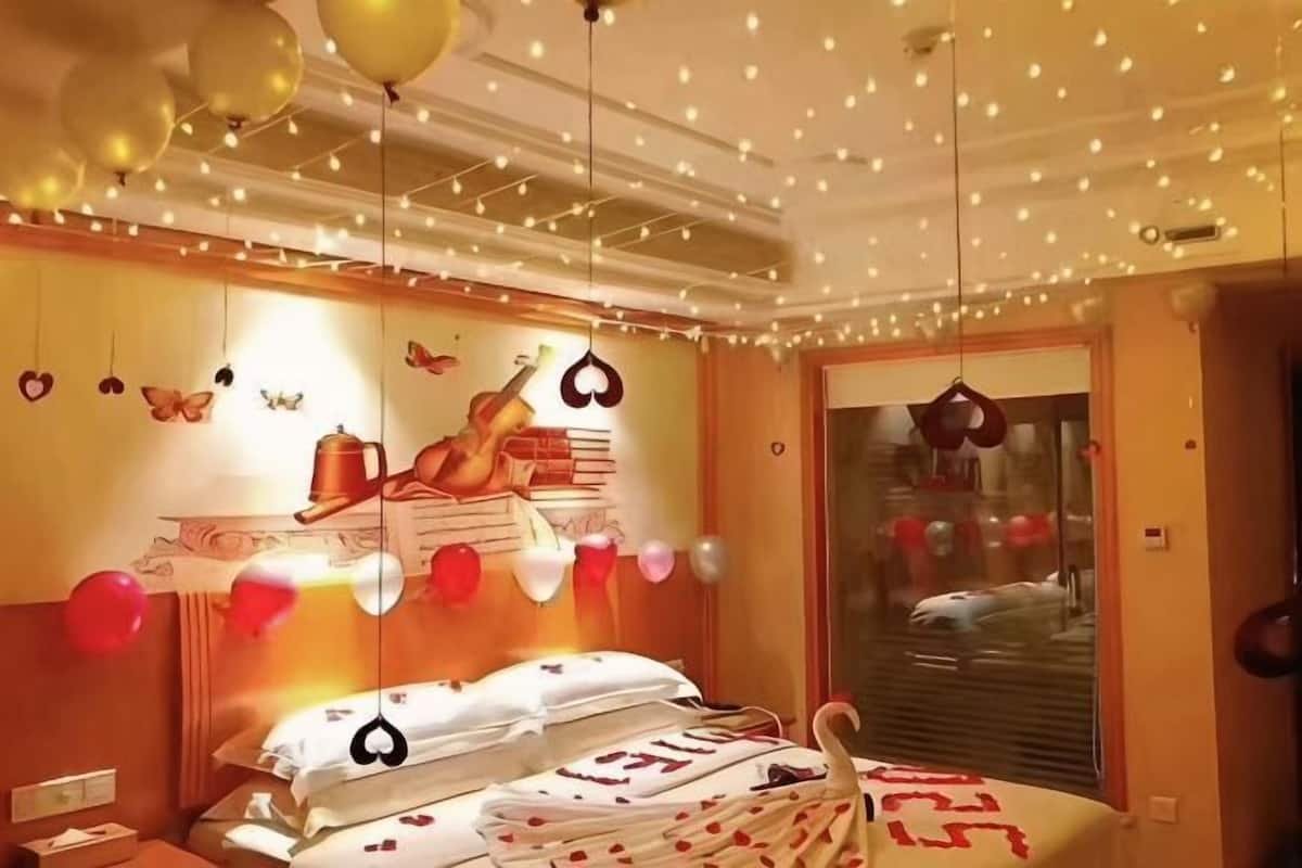 A bedroom with a bed, a window, and a wall with a decorative item.