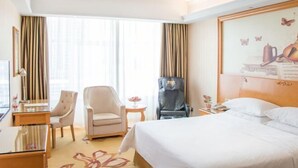 A hotel room with a bed, two armchairs, a desk, and a chair. - Vienna Hotel (Taihe Chengjiang Avenue) (Taihe)