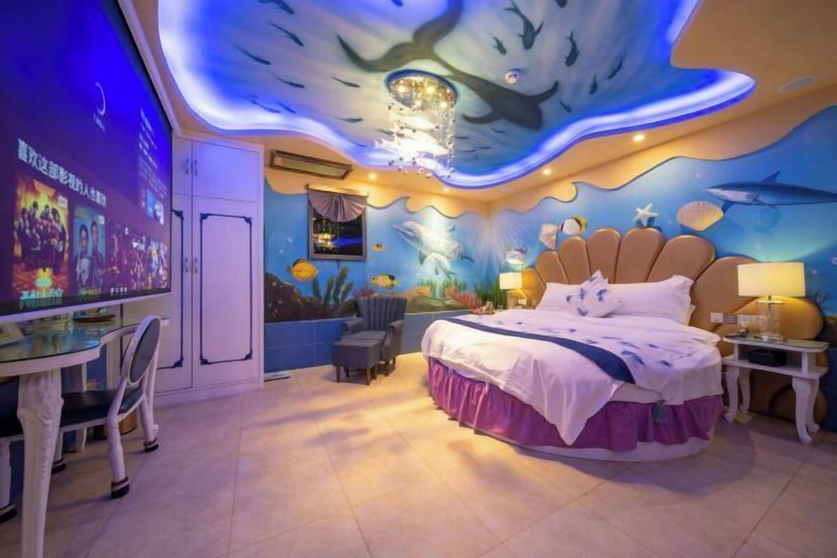 A bedroom with a bed, a desk, and a chair.