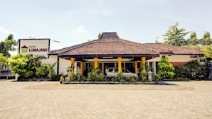 A hotel with a tiled roof and a covered entrance area. - OYO 90250 Hotel Lumajang New (Lumajang)