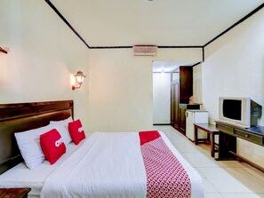 Una habitación de hotel con cama, televisión, escritorio y armario.