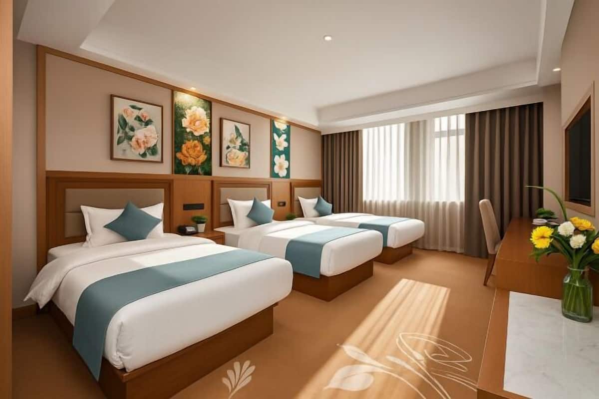 A hotel room with three beds, a desk, and a large window with curtains.