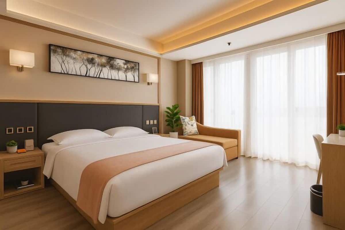 A hotel room with a large bed, bedside tables, a desk, a sofa, and a large window with curtains.