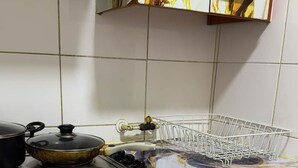 A kitchen with a stove, pots, a dish rack, and a patterned cabinet. - Charming Metro Santa Ana 2 bedrooms (Santiago)