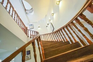 Staircase ascends to an upper level, featuring a handrail and wall-mounted lighting.
