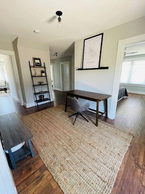 Cozy retreat with a desk, chair, bookshelf, and ceiling light.