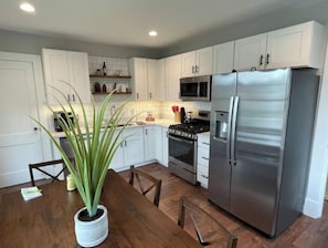 Enjoy cooking and dining in this fully equipped kitchen with a dining table and potted plant.
