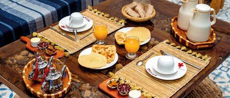 A breakfast table with plates, glasses, and a pitcher.