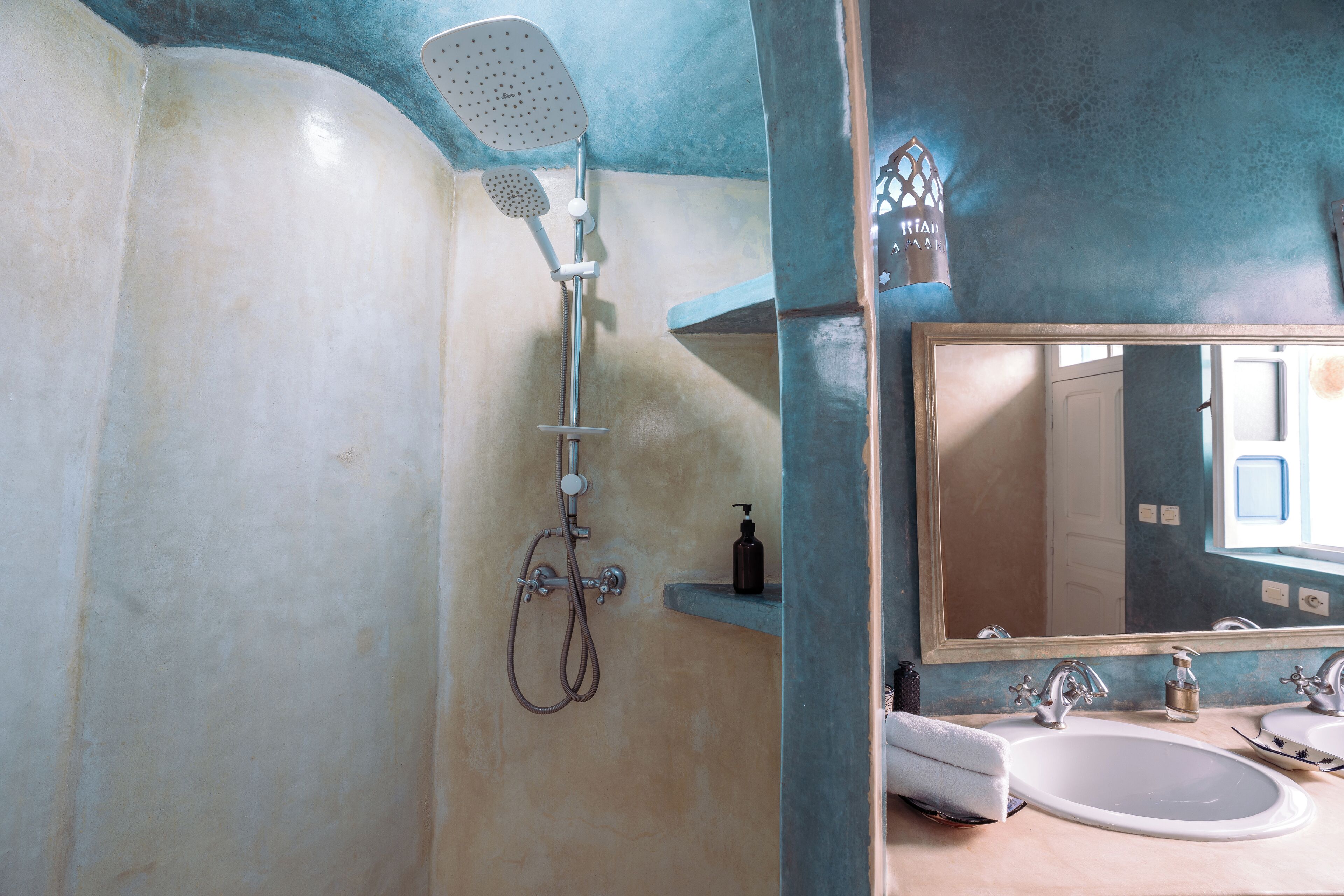 Une salle de bain avec une douche, un lavabo et un miroir.