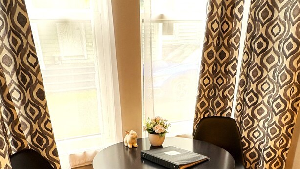 A round table with two black chairs, a small potted plant, and a notebook. - Modern 1 Bedroom, 10 minute walk to Downtown (Moncton)