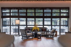 A modern interior with a large window, a sofa set, and a floor lamp. - Vastroam Hotel (Yongtai)