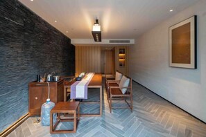 A modern hotel room with a long dining table, wooden chairs, a large window, and a dark textured wall. - Vastroam Hotel (Yongtai)