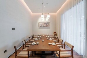 A conference room with a long table, chairs, and a painting on the wall. - Vastroam Hotel (Yongtai)