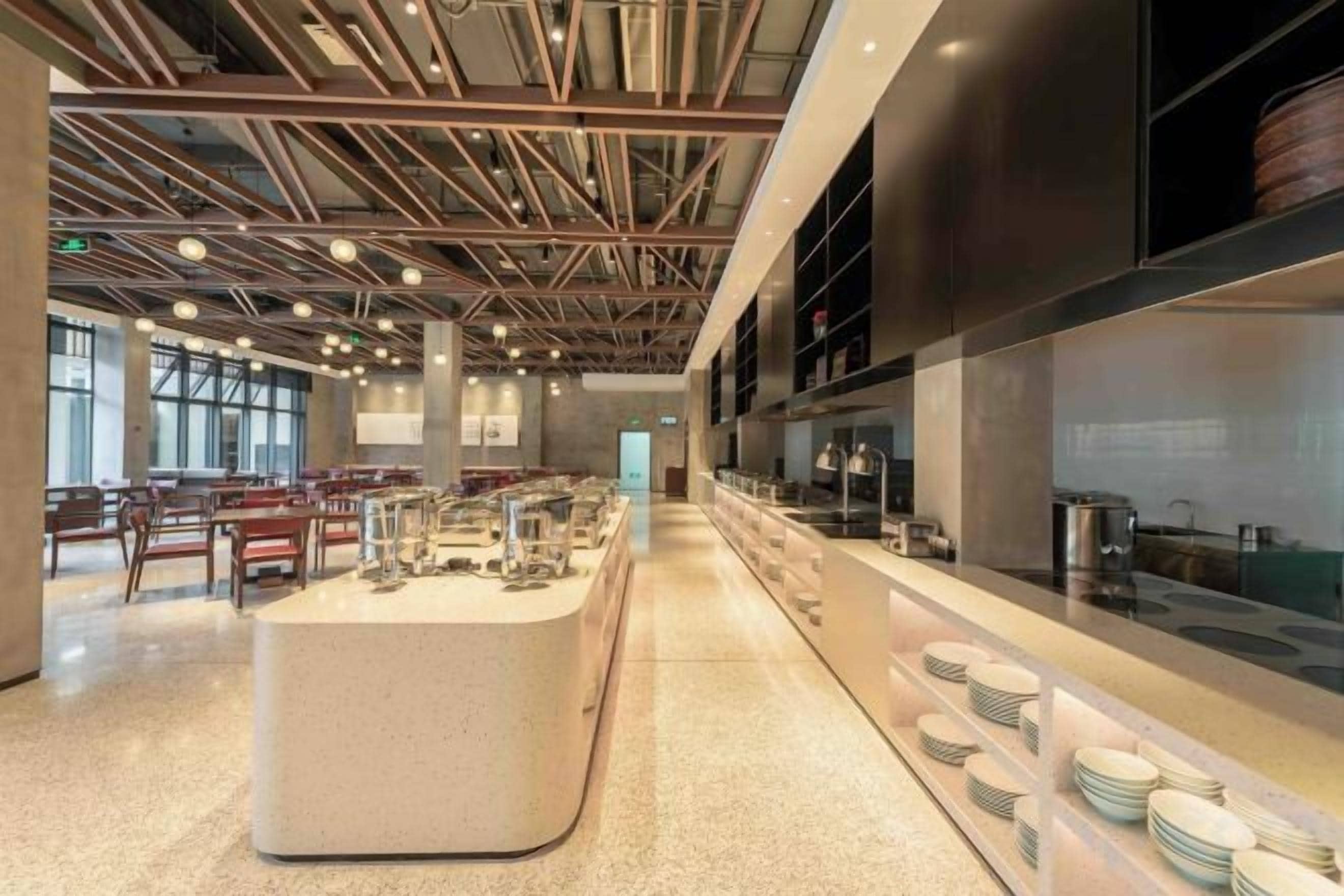 A spacious indoor area with a long counter, seating, and a kitchen area.