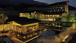 Ein Hotel mit Pool, Sitzgelegenheiten im Freien und Bergblick.