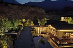 A modern hotel with a rooftop pool, surrounded by lush greenery and mountains in the background. - Vastroam Hotel (Yongtai)