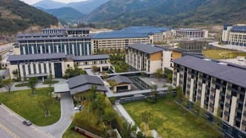 A modern hotel complex with multiple buildings, a central courtyard, and a road in the foreground.