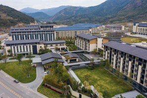 A modern hotel complex with multiple buildings, a central courtyard, and a road in the foreground. - Vastroam Hotel (Yongtai)