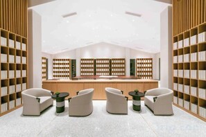 A modern library with bookshelves, a reception desk, and seating areas. - Vastroam Hotel (Yongtai)