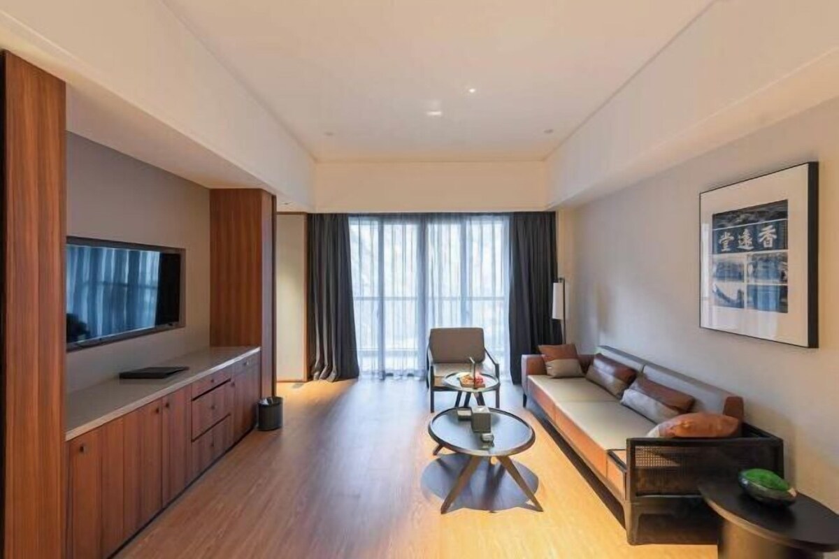 A modern living room with a sofa, a coffee table, and a TV on a wooden cabinet.