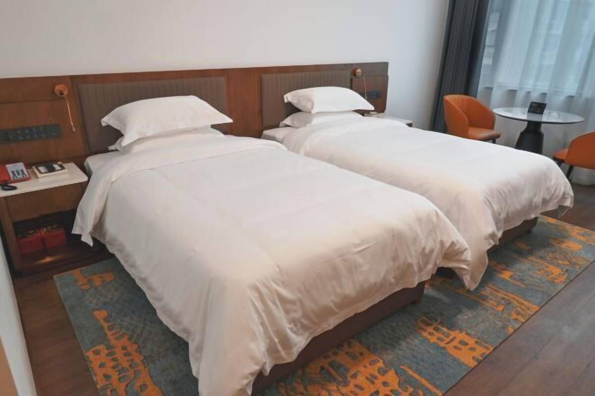 Une chambre d’hôtel avec deux lits, une petite table et une chaise.