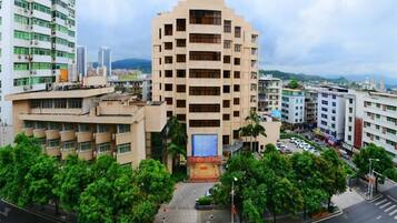 A multi-story building with a central courtyard, surrounded by trees and other buildings.