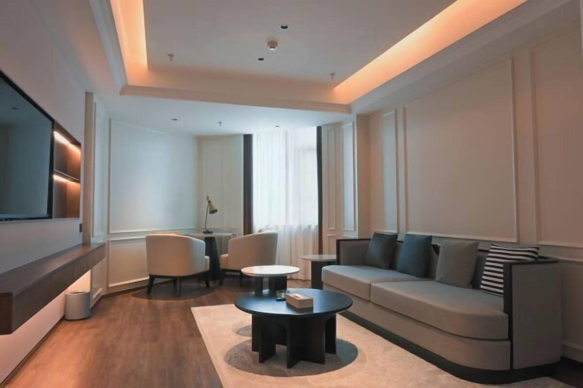 Un salon moderne avec un canapé, une table basse et un téléviseur à écran plat.
