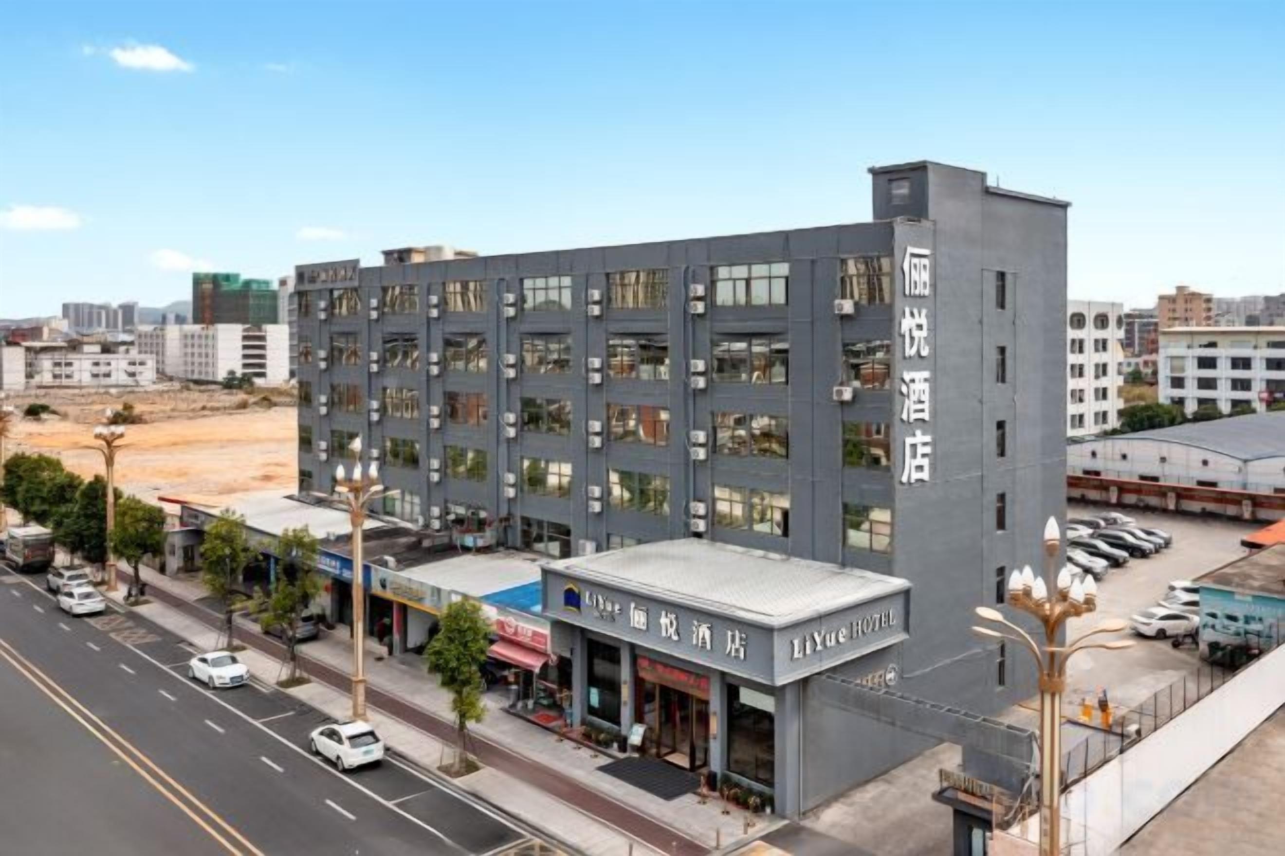 Un hotel de varios pisos con un diseño moderno, que cuenta con un techo plano y una serie de balcones.