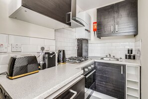 Enjoy cooking in this well-equipped kitchen with an oven, stainless steel range hood, and granite countertop.