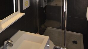 A modern bathroom with a glass shower enclosure, a white sink, and a toilet. - Caesar Panoramic Hotel Restaurant (Bonnieux)