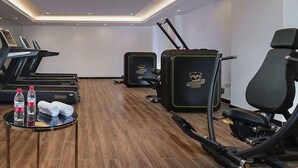 Ein Fitnessraum mit Laufbändern, Fahrrädern und Rudergeräten.