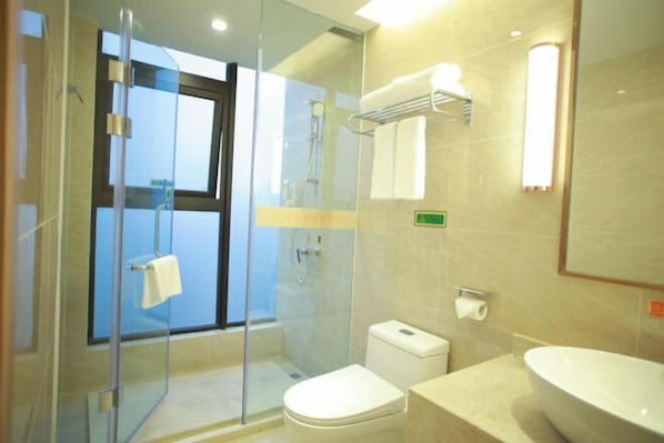 A modern bathroom with a glass-enclosed shower, a toilet, and a sink with a large basin. - Vienna International Hotel (Chengdu)