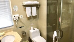 A bathroom with a sink, toilet, and glass shower enclosure. There are towels on a rack and a hand dryer on the wall. - Greentree Inn Suzhou Wuzhong District Fengjin Road Business Hotel (Suzhou)