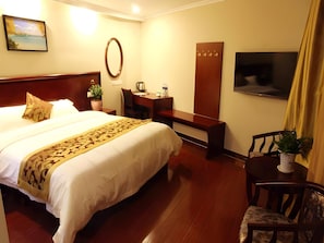 A hotel room with a large bed, a desk, a chair, a TV, and a potted plant. - Greentree Inn Suzhou Wuzhong District Fengjin Road Business Hotel (Suzhou)