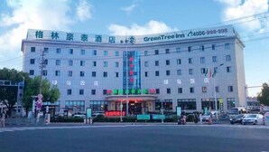 A hotel with a large sign for GreenTree Inn and a smaller sign for a restaurant. - Greentree Inn Suzhou Fengjin Road Business Hotel (Suzhou)