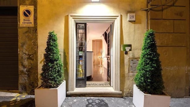 A hotel entrance with a closed door, a sign indicating no parking, and two potted plants on either side. - Romanticasa Navona  (Rome)