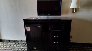 A hotel room with a bed, a TV on a cabinet, a microwave, and a small refrigerator. - Budget inn (Texarkana)
