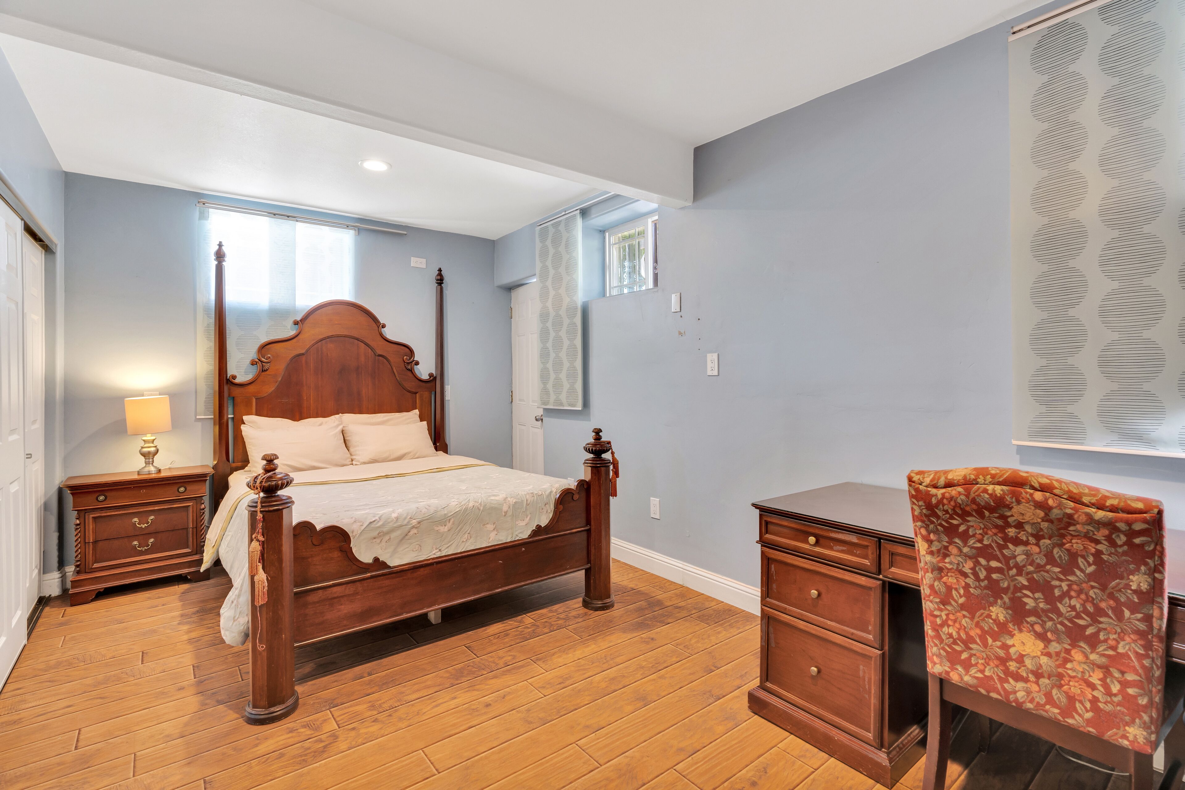 Une chambre à coucher avec un lit en bois, un bureau et une chaise.