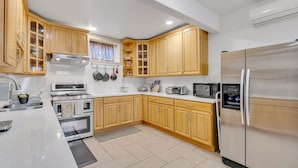Una cocina moderna con armarios de madera, electrodomésticos de acero inoxidable y encimera de mármol.