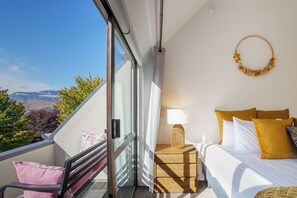 Une chambre d’hôtel avec un lit, une table de chevet et une vue sur les montagnes.