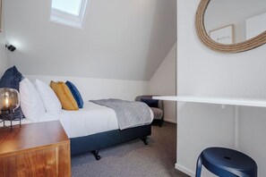A bedroom with a bed, a desk, a chair, and a bedside table. - Sarahs Scenic Stay | Mountain Lake Views (Queenstown)