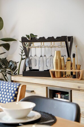 A bar area with a wine rack, glasses, and bar tools. - Sarahs Scenic Stay | Mountain Lake Views (Queenstown)