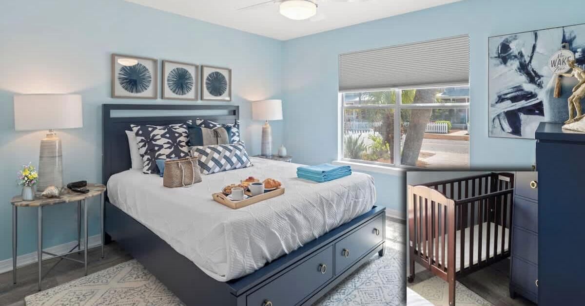 A bedroom with a bed, bedside tables, a crib, and artwork on the walls.