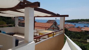 Un balcone con vista sul mare e sugli edifici.