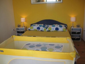 Ein Doppelbett mit blauem Kopfteil und zwei Nachttischen, jeweils mit einer Lampe.